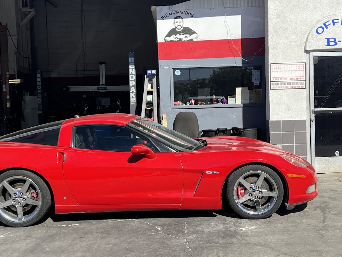 A red Chevrolet Corvette in the service bay at Intake Auto Repair