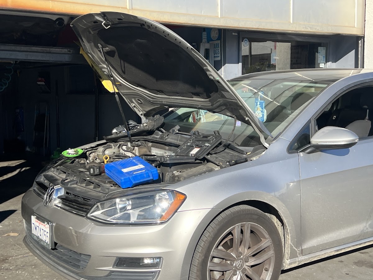 A Volkswagen Golf with the hood raised for engine work